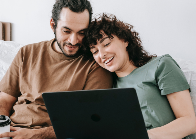Un couple heureux qui regarde leur ordinateur